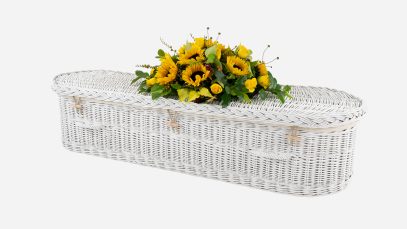 Child's willow coffin with a curved-end shape, painted white in colour and featuring painted white woven willow handles