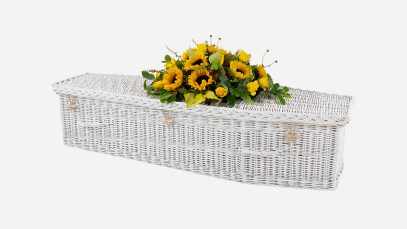 Child's willow coffin with a traditional shape, painted white in colour and featuring painted white woven willow handles