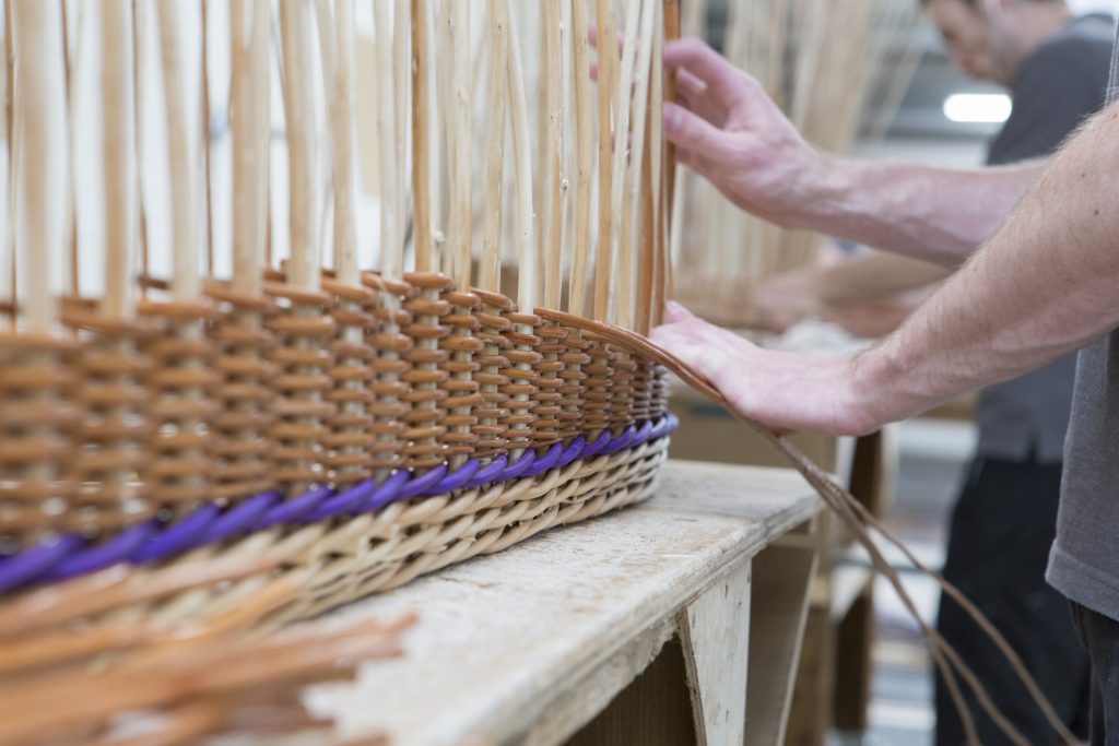 Willow craftsman weaving the side of a willow coffin